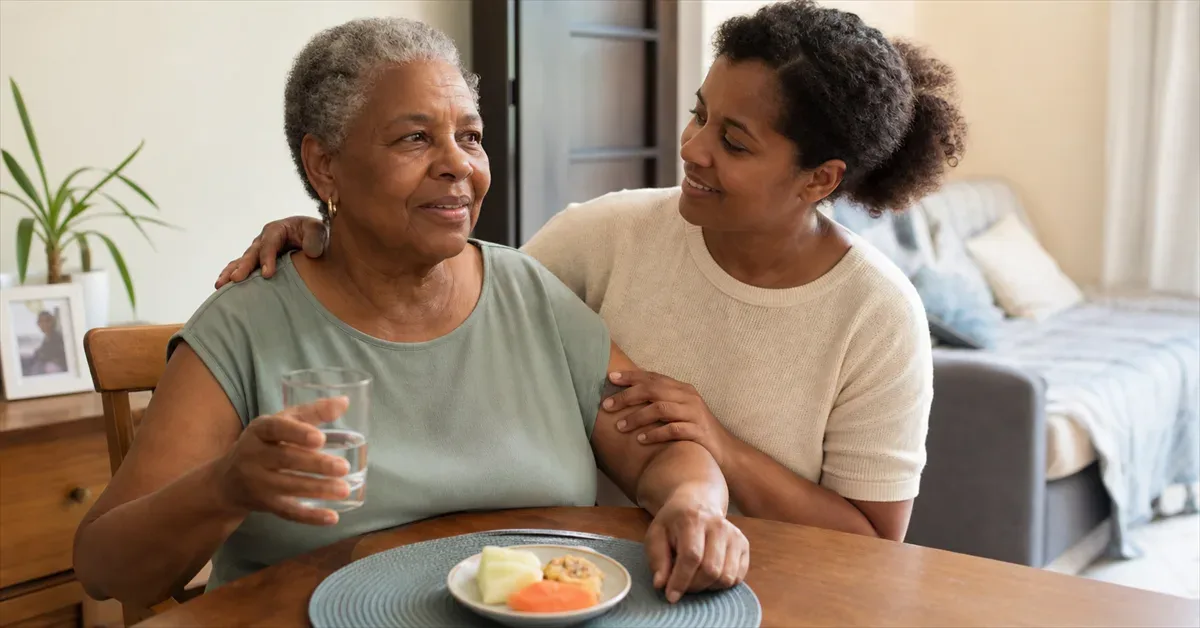Older adult seated after a meal with caregiver support